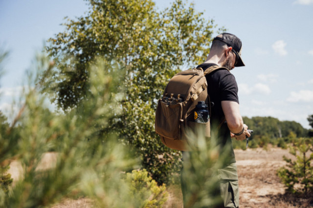 Mann mit Helikon-Tex Rucksack in sommerlicher Waldlandschaft