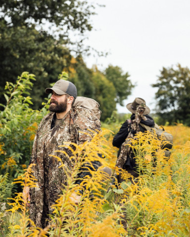 Zwei Jäger in Tarnkleidung durchqueren dichtes Herbstgras – Modern Hunting Collection von TACWRK.